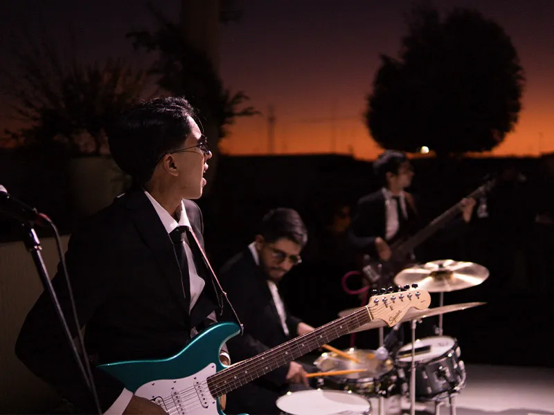 Banda en vivo con guitarras y batería al atardecer